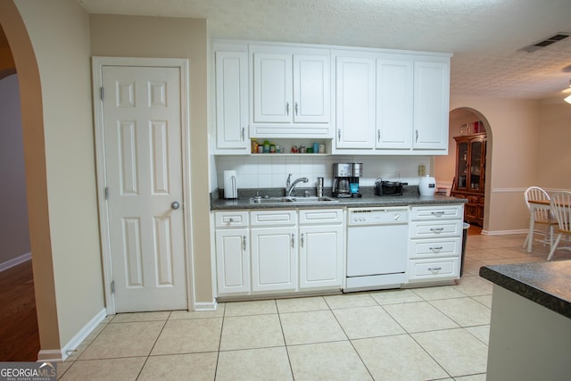 kitchen with dishwasher, light tile patterned floors, arched walkways, and a sink