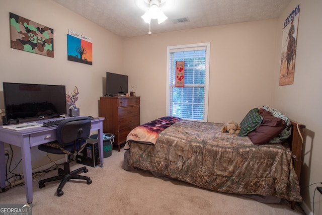 bedroom with carpet flooring, visible vents, and a textured ceiling