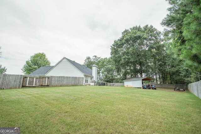 view of yard featuring an outbuilding, a storage unit, and a fenced backyard