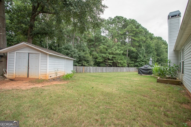 view of yard with an outdoor structure, fence, and a shed