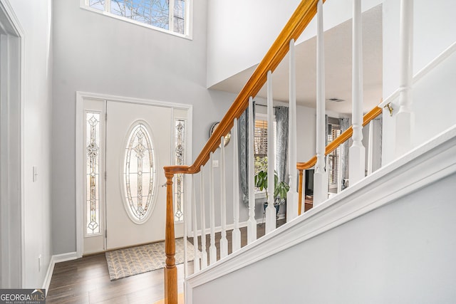 foyer entrance featuring a healthy amount of sunlight, wood finished floors, and stairs