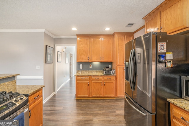 kitchen featuring visible vents, ornamental molding, appliances with stainless steel finishes, light stone countertops, and dark wood-style flooring