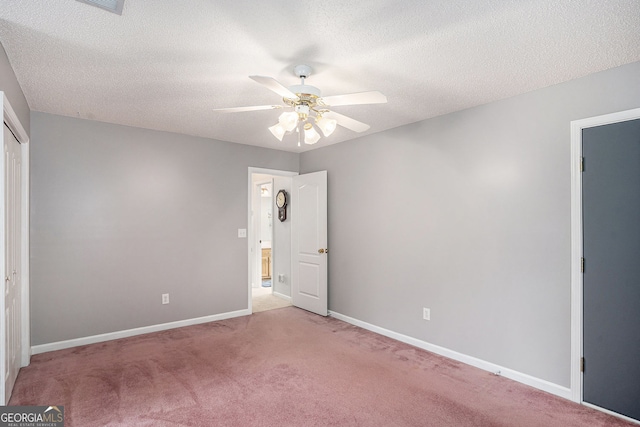 unfurnished bedroom with light carpet, a textured ceiling, baseboards, and a closet