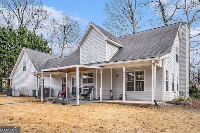 cape cod house featuring a patio, covered porch, a front yard, and roof with shingles