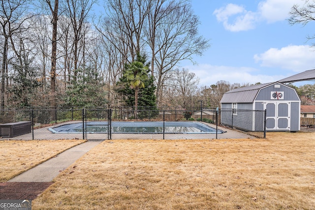 view of pool featuring an outbuilding, a storage unit, a yard, and fence