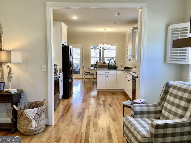 kitchen featuring dishwashing machine, white cabinets, black fridge with ice dispenser, and ornamental molding