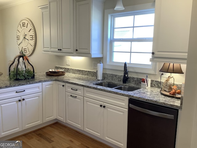 kitchen with dishwasher, white cabinetry, and a sink