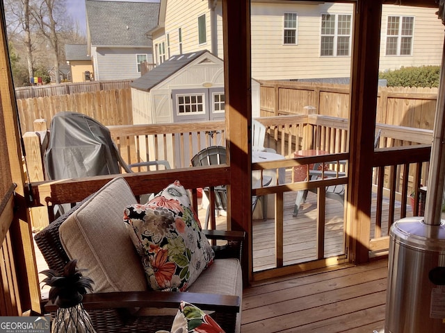 wooden deck with area for grilling, an outdoor structure, and fence