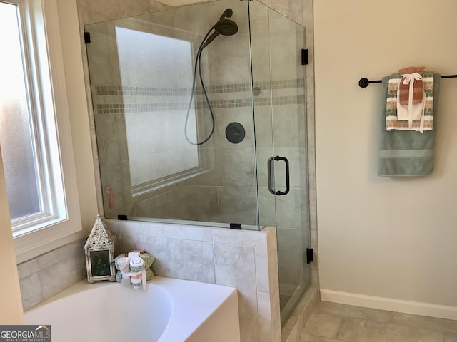 full bathroom featuring a bath, a stall shower, and baseboards