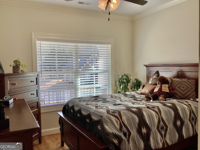 bedroom featuring light wood-style flooring and crown molding