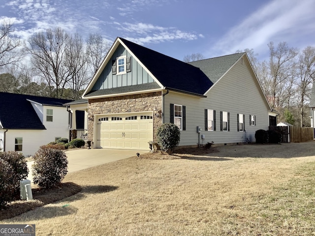 view of front facade with a lawn, driveway, stone siding, board and batten siding, and a garage