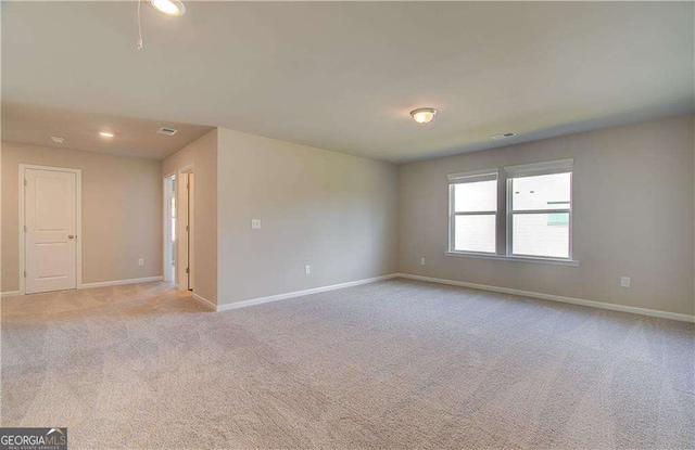 spare room with visible vents, recessed lighting, light colored carpet, and baseboards