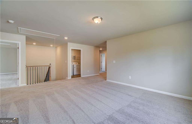 spare room featuring washer / dryer, baseboards, carpet, and attic access