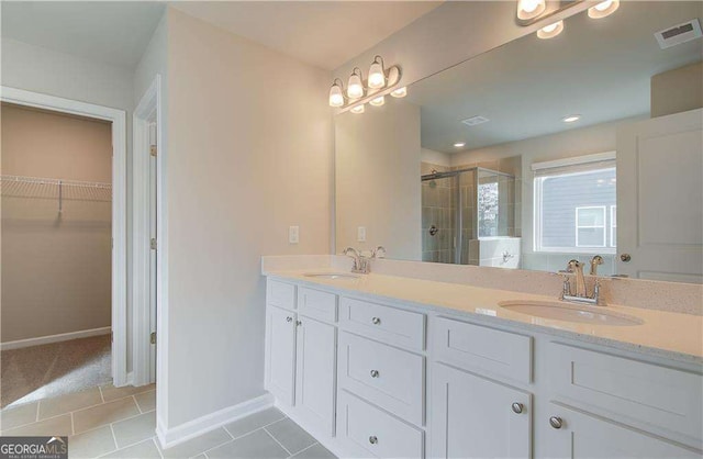 full bath featuring a sink, visible vents, a walk in closet, and a shower stall