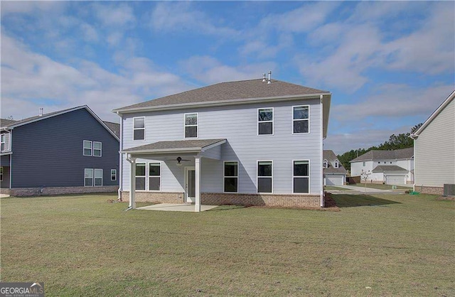 rear view of house featuring brick siding, a lawn, and a patio area