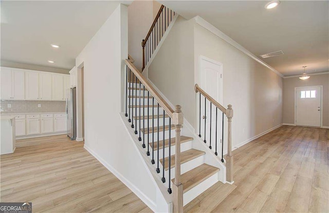 interior space with light wood finished floors, recessed lighting, baseboards, and ornamental molding