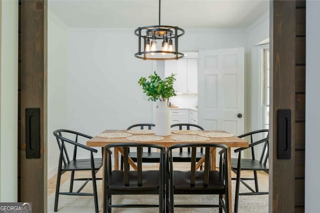 dining space with baseboards, light wood-style floors, a chandelier, and crown molding