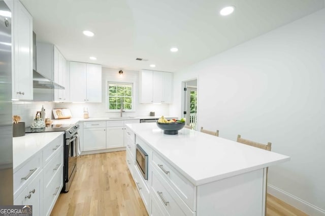 kitchen with white cabinetry, light countertops, appliances with stainless steel finishes, and a sink