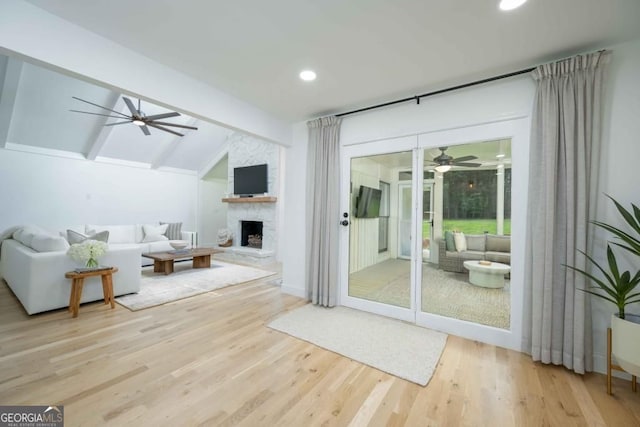 living room with a fireplace, lofted ceiling with beams, a ceiling fan, and wood finished floors