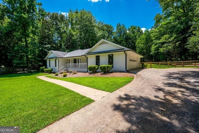 single story home with a front lawn, fence, aphalt driveway, a porch, and an attached garage