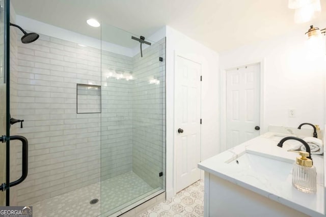 full bathroom featuring double vanity, a stall shower, and a sink