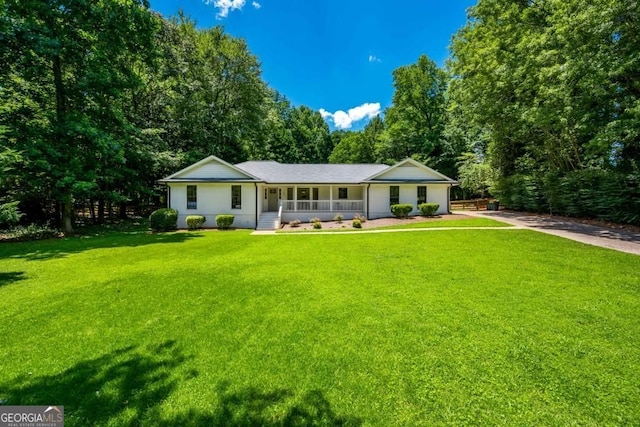 ranch-style house with a front yard, covered porch, and driveway