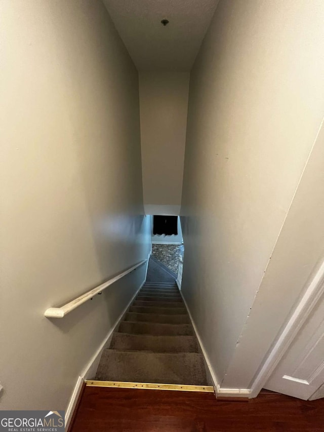 staircase with wood finished floors and baseboards