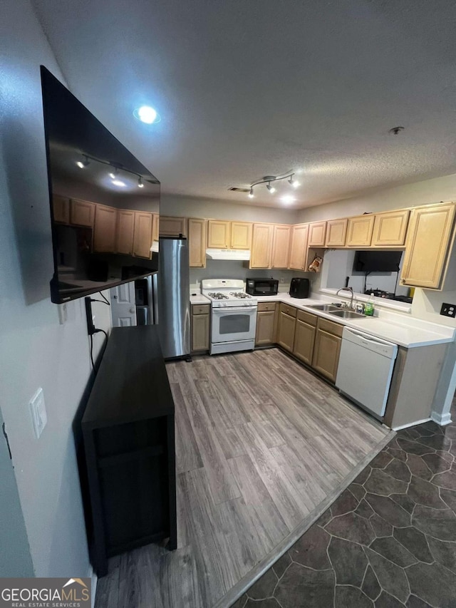 kitchen with light brown cabinets, under cabinet range hood, wood finished floors, white appliances, and a sink