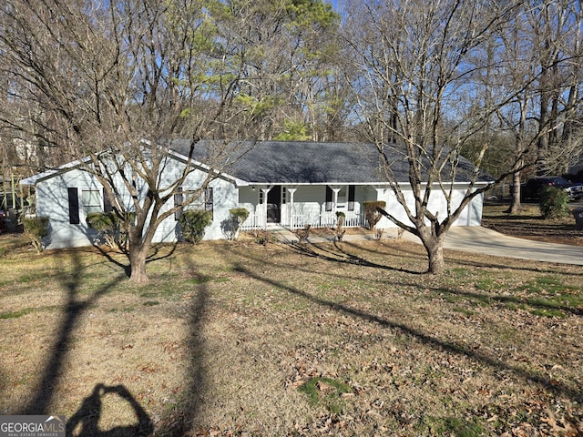 ranch-style home featuring a porch, an attached garage, concrete driveway, and a front lawn