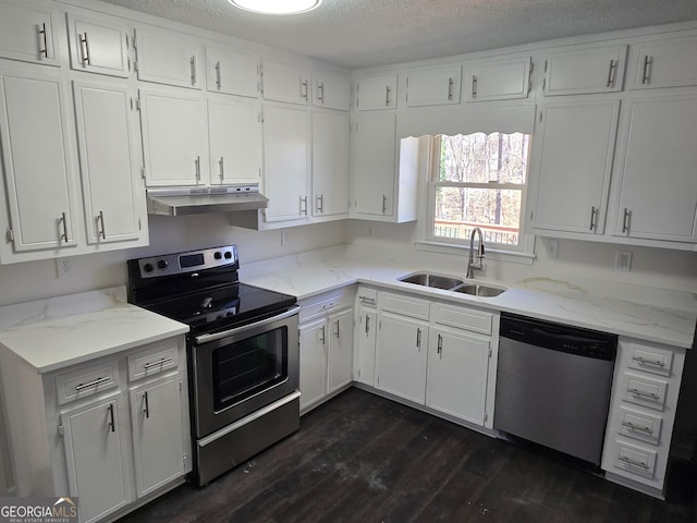 kitchen featuring dark wood-style flooring, a sink, under cabinet range hood, appliances with stainless steel finishes, and white cabinetry