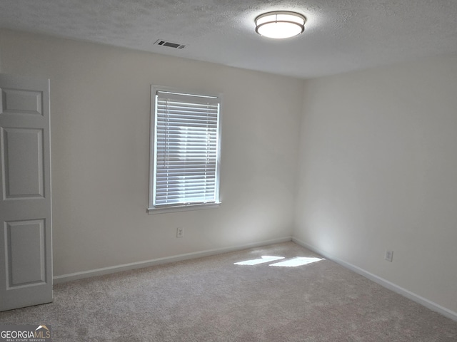 unfurnished room featuring baseboards, visible vents, carpet floors, and a textured ceiling