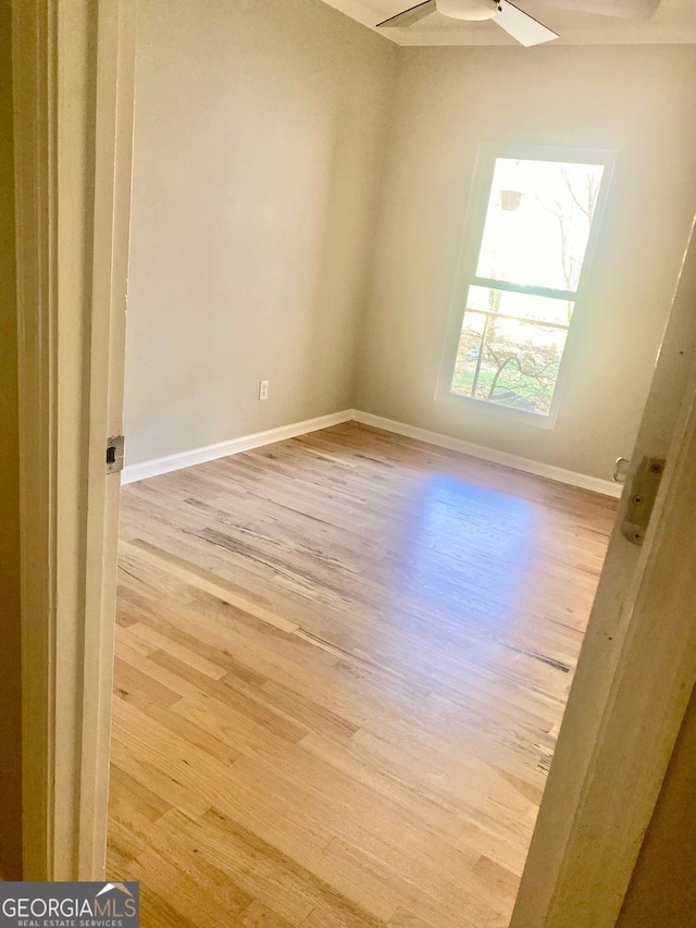 spare room with wood finished floors, baseboards, and ceiling fan