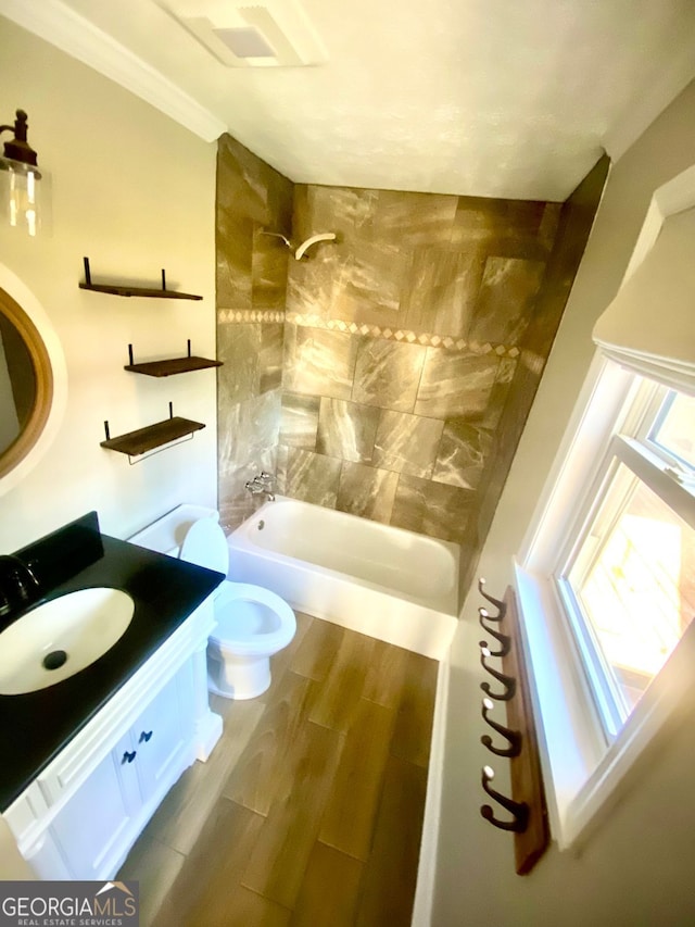 full bath with wood tiled floor, toilet, ornamental molding, bathtub / shower combination, and vanity