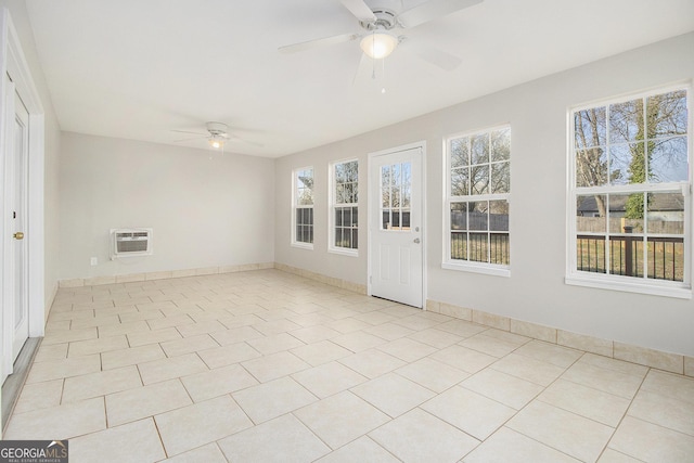 unfurnished sunroom with a wall mounted air conditioner and a ceiling fan