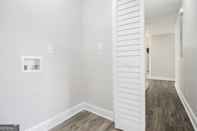 clothes washing area featuring washer hookup, laundry area, wood finished floors, and baseboards