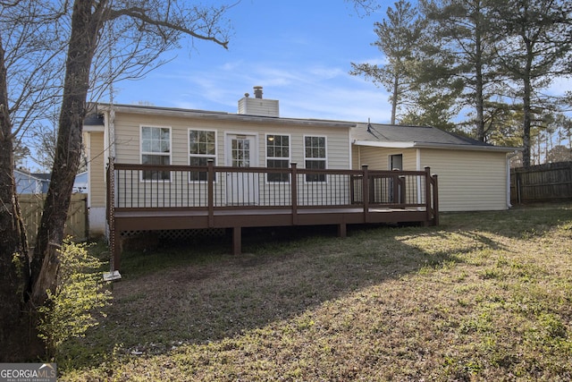 rear view of property featuring a deck, a yard, a fenced backyard, and a chimney