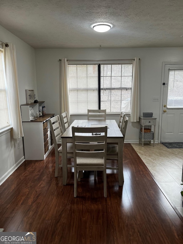 dining area with wood finished floors, baseboards, and a textured ceiling