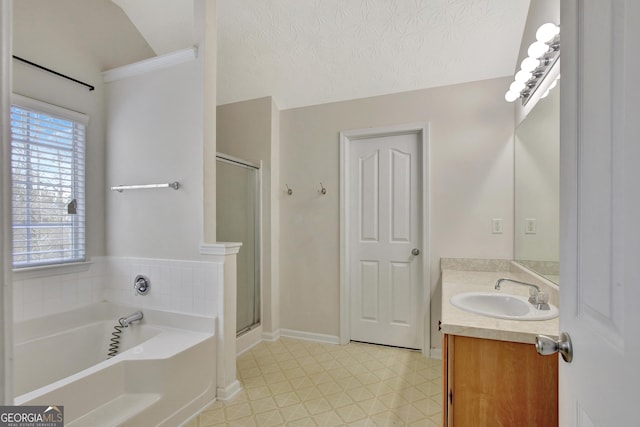 bathroom with a shower stall, tile patterned floors, a bath, a textured ceiling, and vanity