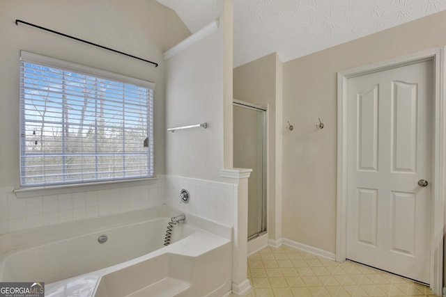 bathroom featuring baseboards, a shower stall, a textured ceiling, tile patterned floors, and a bath