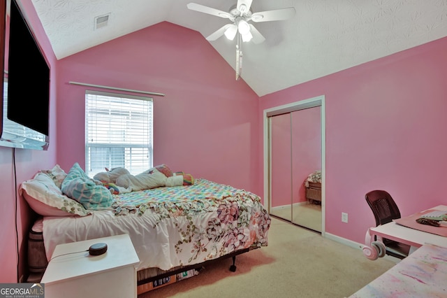 bedroom with carpet, visible vents, lofted ceiling, ceiling fan, and a closet