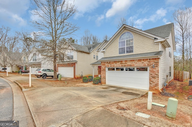 traditional home with a garage, brick siding, driveway, and a shingled roof