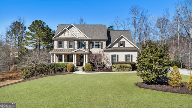 view of front of home featuring a standing seam roof, a front yard, and a porch