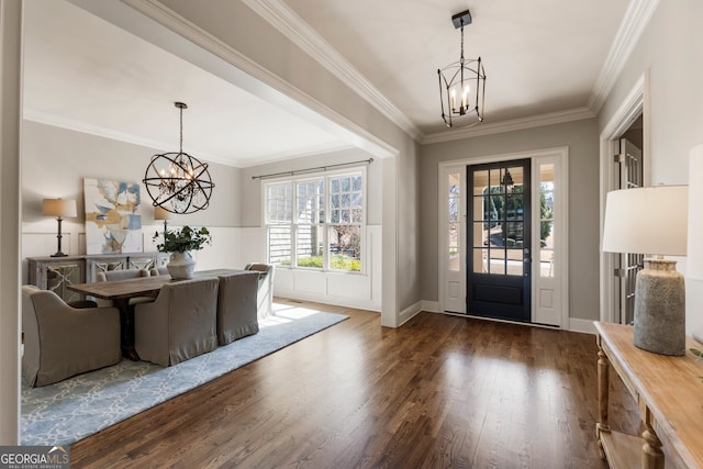 entryway with a notable chandelier, dark wood finished floors, and crown molding