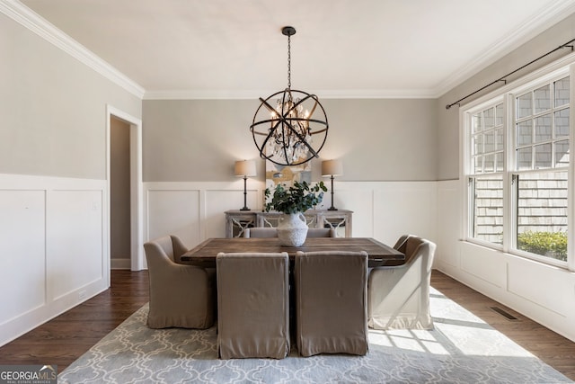 dining area with a notable chandelier, wood finished floors, visible vents, and ornamental molding