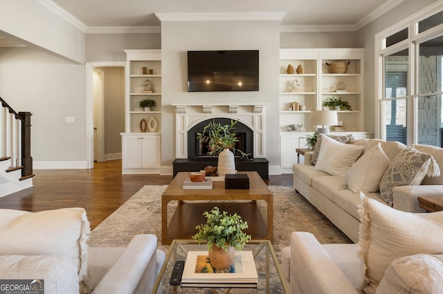 living area with stairway, wood finished floors, baseboards, a high end fireplace, and ornamental molding