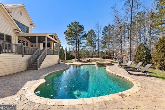 view of swimming pool with a patio area, stairway, a pool with connected hot tub, and a sunroom