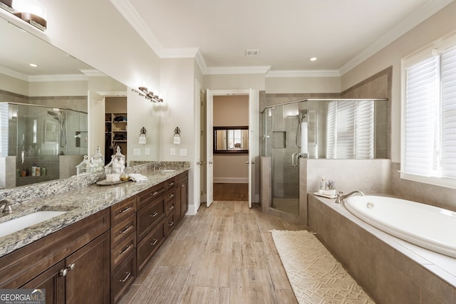 full bath featuring a shower stall, wood finished floors, a garden tub, and a sink