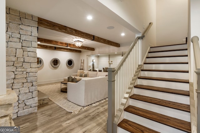 unfurnished living room with recessed lighting, beam ceiling, wood finished floors, and stairs