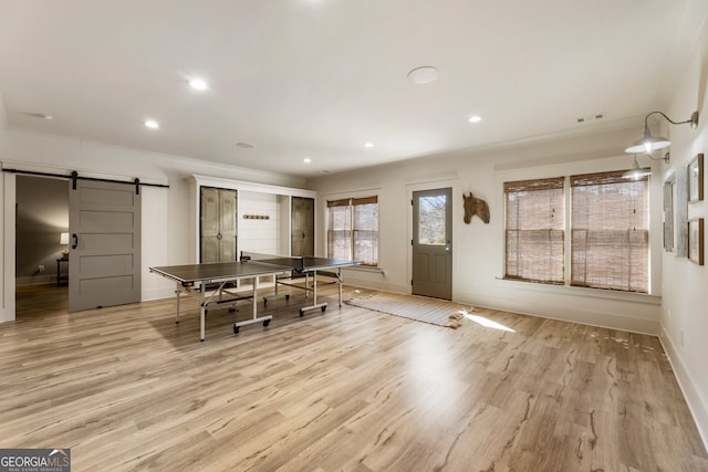 dining space featuring a barn door, recessed lighting, visible vents, and light wood-type flooring