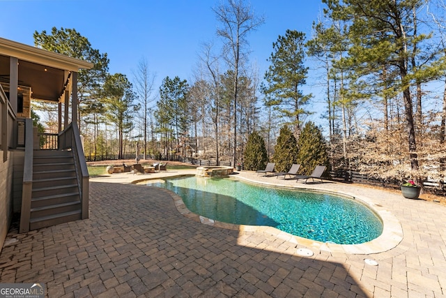 view of swimming pool with a pool with connected hot tub, stairs, a patio, and fence